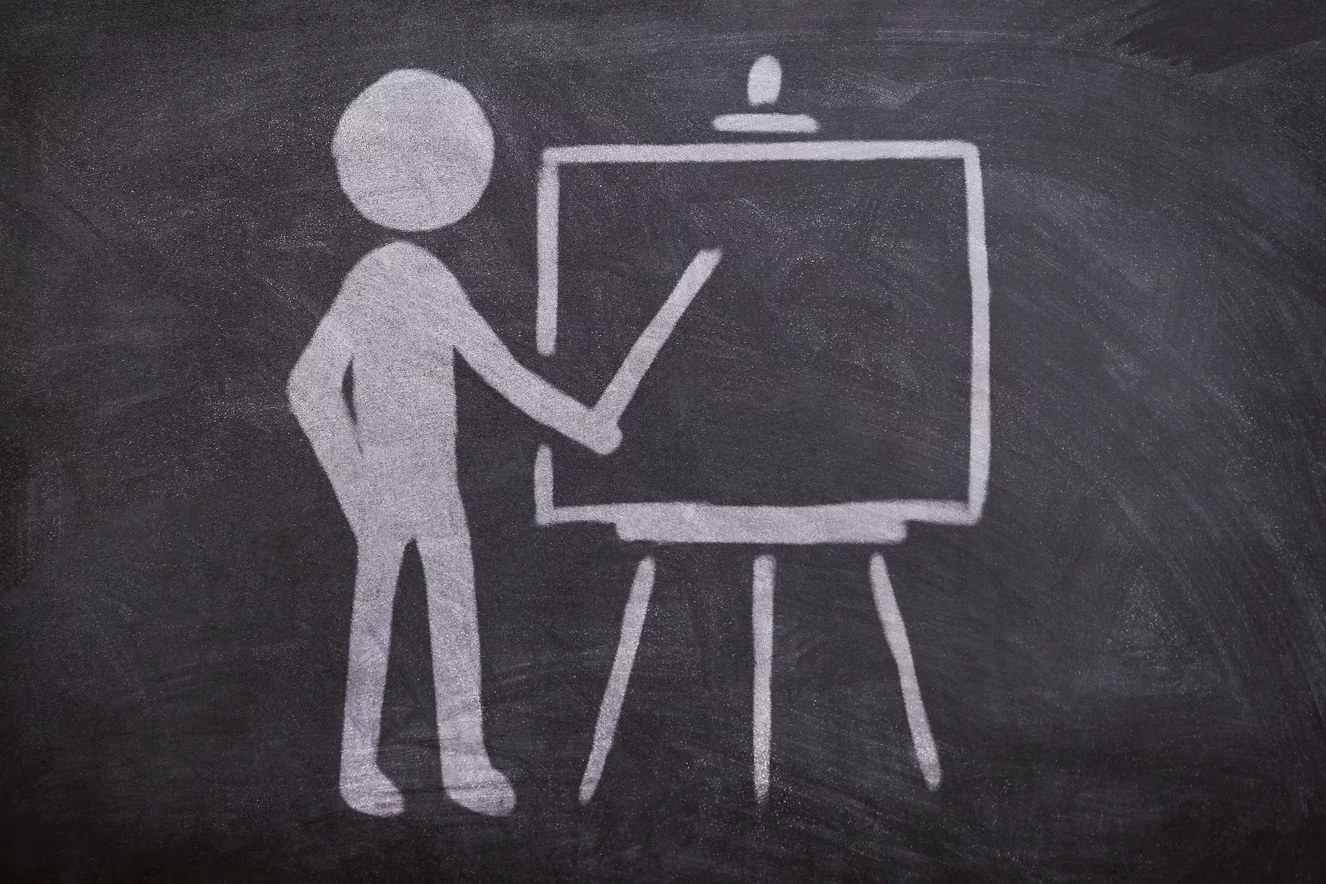 Symbolbild eines Lehrer mit Zeigestab an einer Tafel 